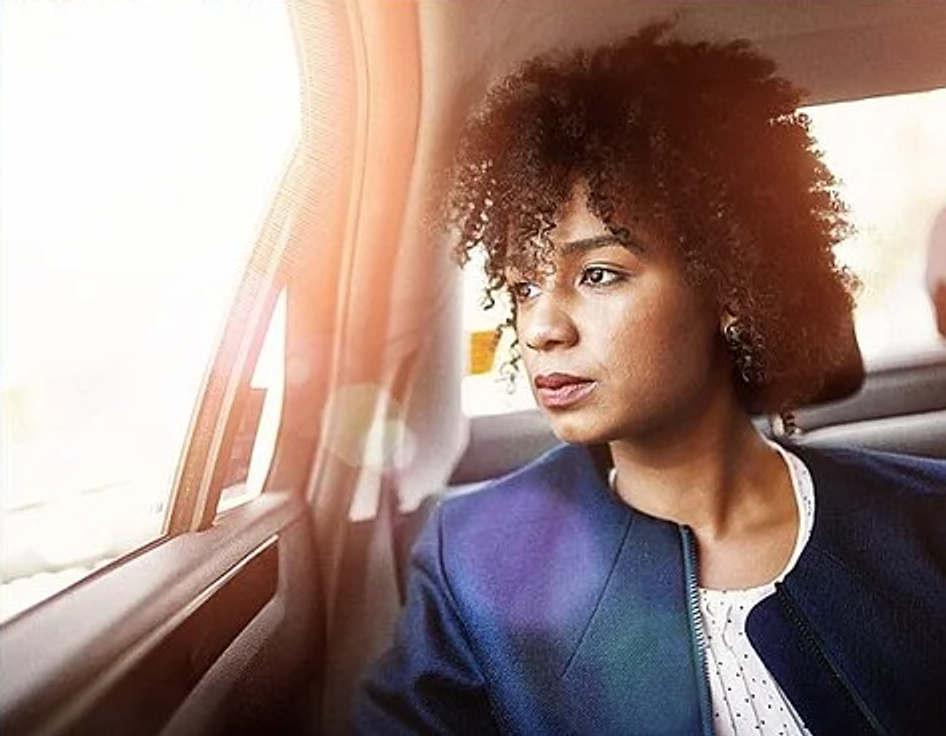 Eine Frau im Auto blickt aus dem Fenster